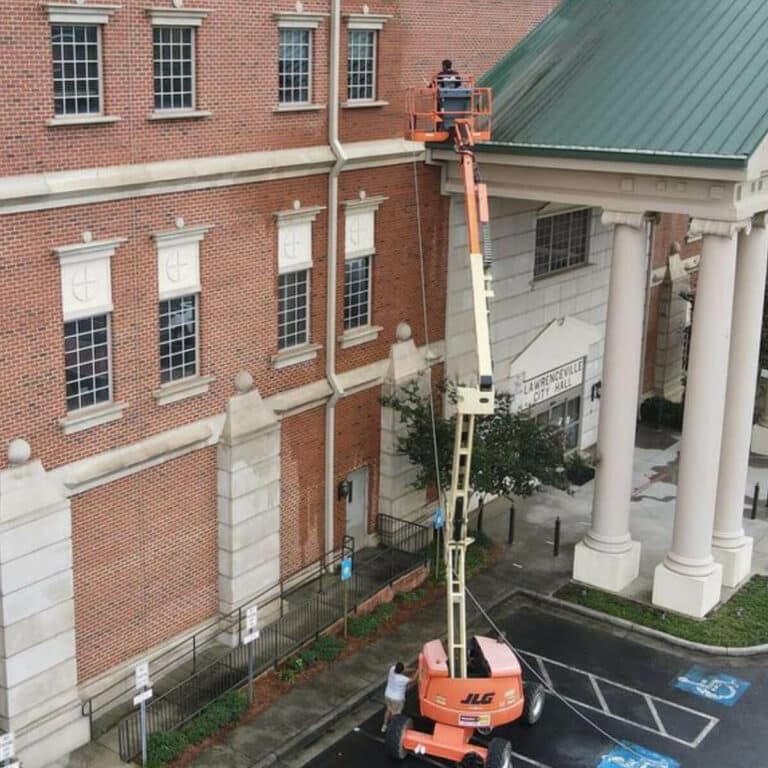 Professionals performing gutter cleaning service for buildings in suwanee georgia